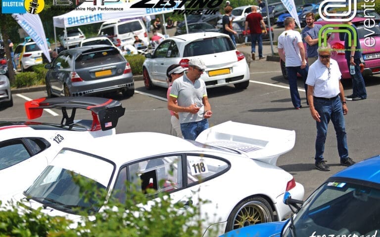 people in the nurburgring car park in the sunshine