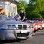 A group of sports cars lined up in the sunshine at the nurburgring